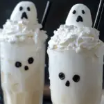 Ghoulish Ghostly White Floats with vanilla ice cream, lemon-lime soda, candy eyes, and black licorice, perfect for Halloween celebrations.