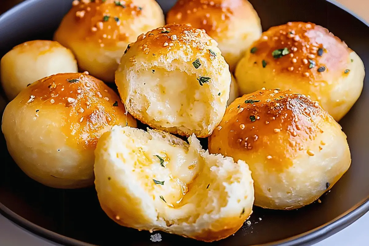 Golden Pillsbury Biscuit Garlic Butter Cheese Bombs with melted cheese inside, brushed with garlic butter, and sprinkled with parsley and Parmesan.