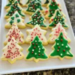 Christmas Sugar Cookies in holiday shapes, decorated with colorful royal icing, sprinkles, and edible glitter for a festive celebration.