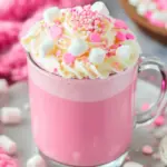 Pink Hot Chocolate in a festive mug topped with whipped cream, marshmallows, and sprinkles