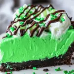 Shamrock Mint Milkshake Pie topped with whipped cream, chocolate drizzle, and green sprinkles