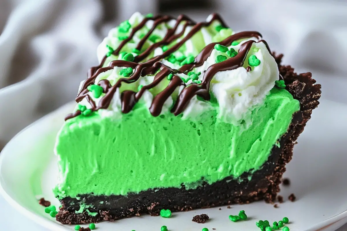 Shamrock Mint Milkshake Pie topped with whipped cream, chocolate drizzle, and green sprinkles