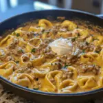 A skillet filled with creamy Beef Stroganoff Tortellini, featuring tender beef, mushrooms, and a rich sauce.