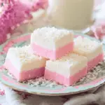 Slices of pink and white coconut ice stacked on a plate, a classic Australian no-bake treat.