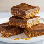 Chocolate-topped Aussie crunch slice with coconut and cornflake base, cut into neat squares