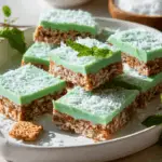 Sliced Aussie Crunch Minty Chocolate Coconut bars topped with green mint chocolate and coconut flakes